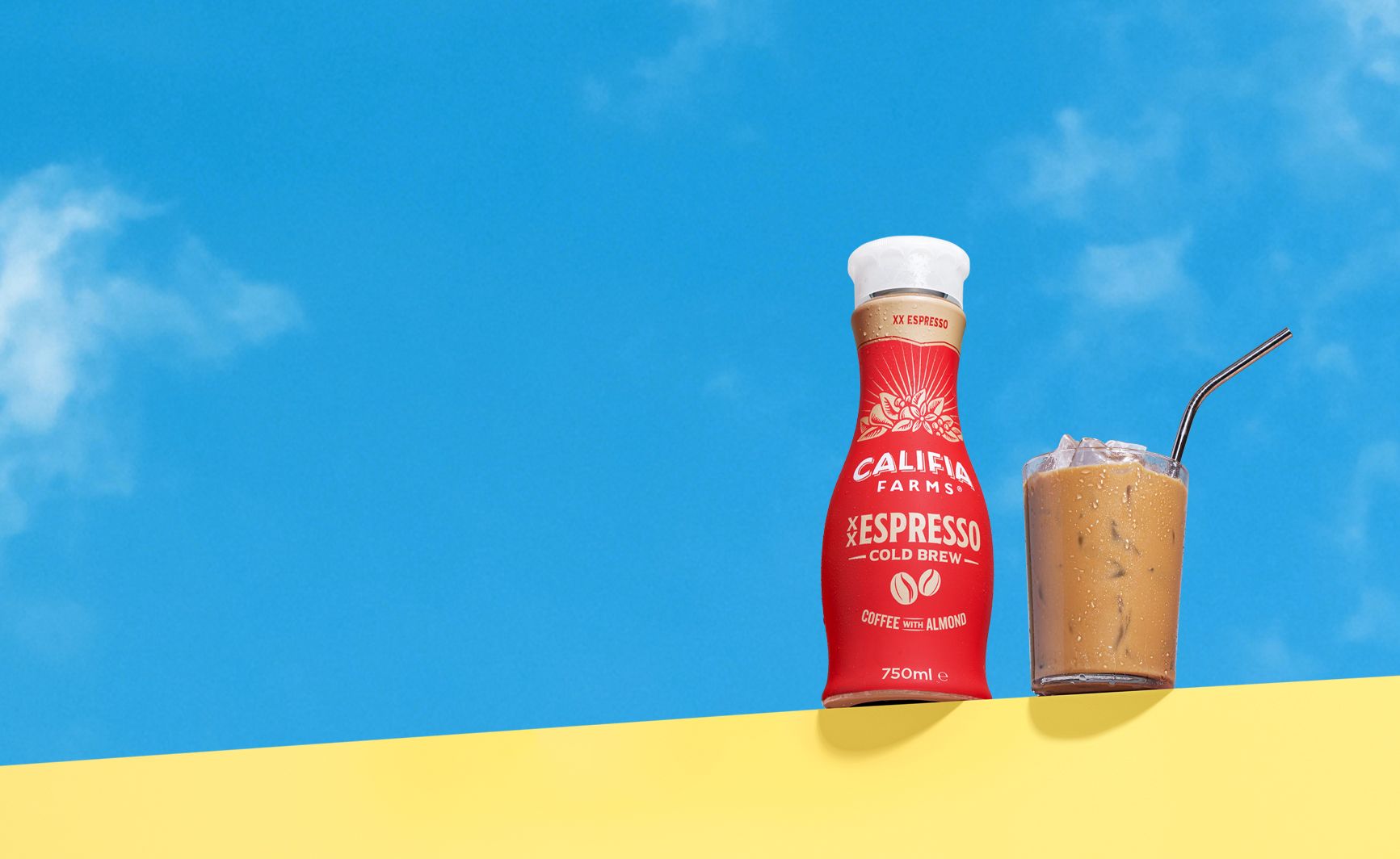 Califia Farms Red XX Espresso bottle against a blue sky background.